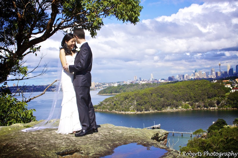 Groom kissing brides head with Sydney Harbour in the background - wedding photography sydney